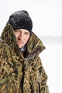 Male wearing camouflage jacket and beanie on frozen Green Lake, Minnesota