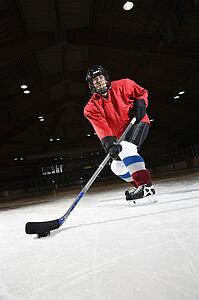Woman hockey player skating on ice lining up to shoot puck