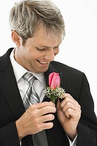 Groom adjusting boutonniere