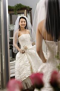 Bride admiring dress in mirror