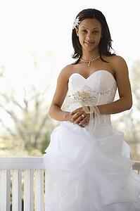 Portrait of bride leaning against railing