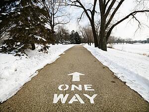 Paved path in park reading one way.