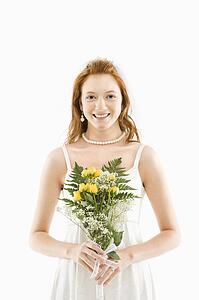 Portrait of Caucasian bride holding bouquet.