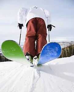 Rear view of mid-adult male on skis in Steamboat, Colorado