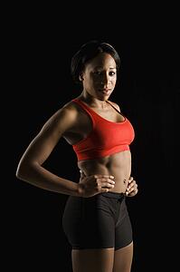 African American young adult woman in athletic apparel with hands on hips.