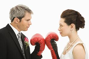 Groom and bride wearing boxing gloves