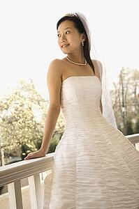 Bride leaning against railing
