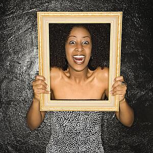 Woman holding frame over her face