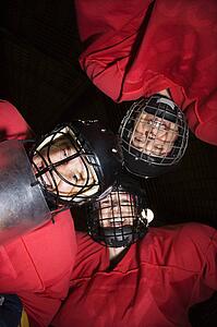 Low angle of female hockey players in huddle smiling