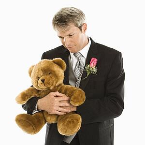 Groom hugging teddy bear