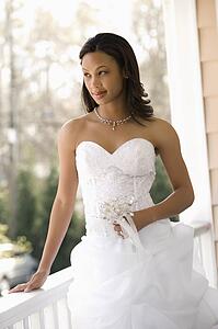 Bride leaning against railing