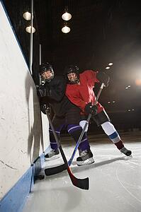 Women hockey players fighting for puck making contact