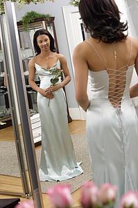Woman in a elegant evening gown looking in mirror
