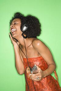 African-American woman listening to music through headphones.