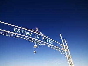 Gate entrance to graveyard reading esting in peace.