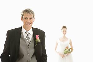 Groom in foreground and bride in background