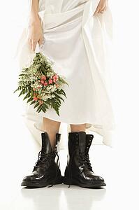 Bride holding bouquet down by her black combat boots