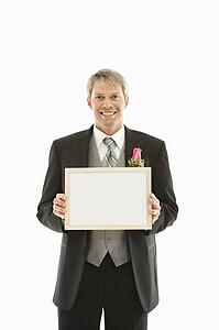 Groom holding blank white sign