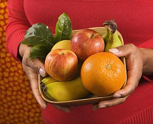 Close up of Hispanic female hands holding a fruit basket.