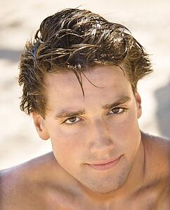 Head and shoulder portrait of handsome man on beach