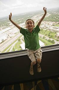 Boy sitting on observation deck at Tower of the Americas in San Antonio, Texas