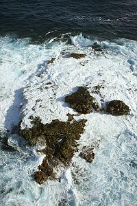 Aerial view of rocks in Pacific ocean with water swirling around them off the coast of Maui, Hawaii