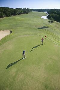 Aerial view of mid adult Caucasian man and woman playing golf at Bald Head Island, North Carolina.