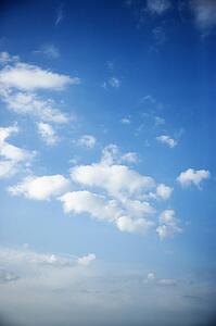 Fluffy cumulus clouds in blue sky.