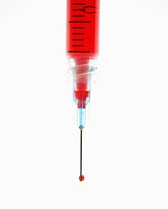 Hypodermic needle filled with red liquid.