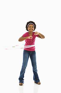 Girl playing with hula hoop and smiling at viewer