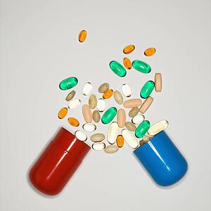 Container with spilt pills and vitamins.