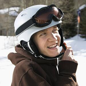 Male teenager fastening helmet