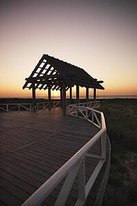 Gazebo at North Carolina coast with setting sun in background.