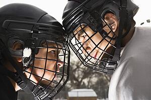 Two ice hockey players in uniform facing off trying to intimidate each other.