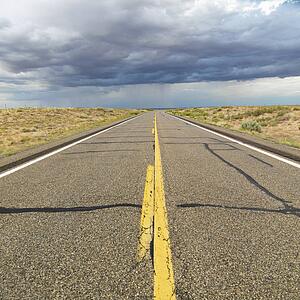 Empty two lane highway leading to desert horizon