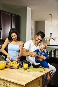 Family with toddler in kitchen at breakfast