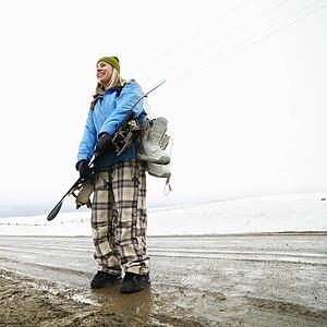 Woman standing holding snowboard