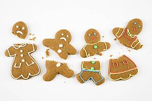 Four frowning male and female gingerbread cookies broken into pieces. 