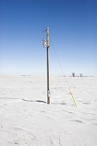 Power line in desolate snow covered rural landscape