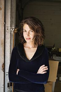 Portrait of pretty Caucasian woman standing with arms crossed making eye contact.
