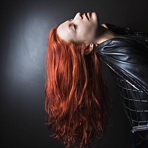Woman wearing leather jacket leaning back in chair