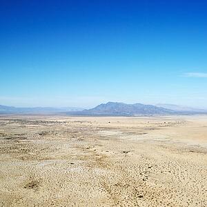 Aerial view of remote California desert with mountain range in background