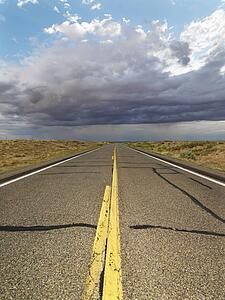 Empty two lane highway leading to desert horizon