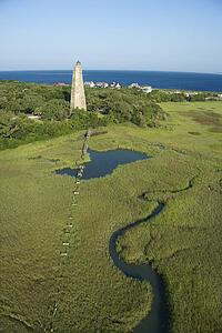 Aerial view of Old Baldy lighthouse in marshy lowlands of Bald Head Island, North Carolina.