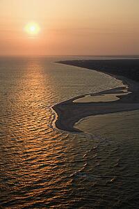 Aerial view of sun over Atlantic ocean and shoreline of Bald Head Island, North Carolina