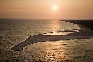 Aerial view of sun over Atlantic ocean and shoreline of Bald Head Island, North Carolina