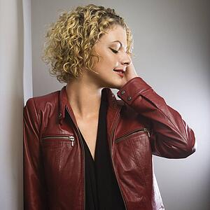 Woman in red jacket with hand touching face