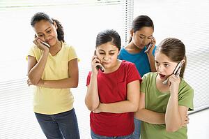 Preteen girls of multiple ethnicities talking on cell phones