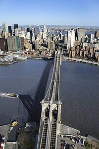 Aerial view of Brooklyn Bridge with East River and Manhattan buildings in New York City.