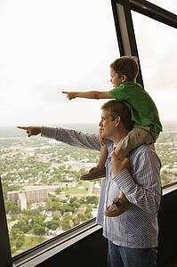 Father and son pointing from observation deck at Tower of the Americas in San Antonio, Texas